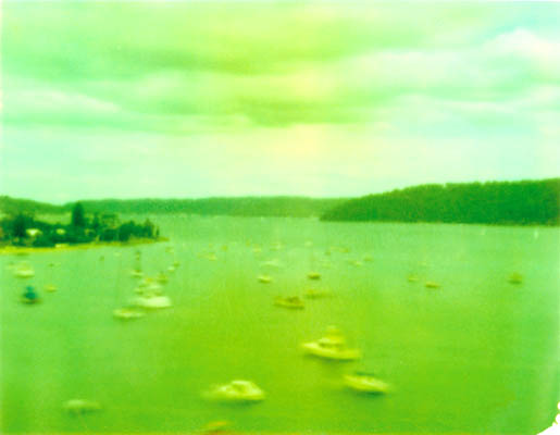 Boats scattered across green-toned water at Palm Beach.
